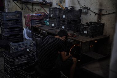 Kurban Bayramı için hazırlıklar tamamdır. 25 Haziran 2023, Gazze, Filistin: Filistinli işçiler, Filistinli kasaplar için keskin aletler ve bıçaklar hazırlama ve keskinleştirme konusunda uzmanlaşmış Gazze Şeridi 'nin merkezindeki El Fari dükkanında çalışıyorlar.