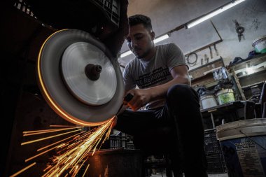 Kurban Bayramı için hazırlıklar tamamdır. 25 Haziran 2023, Gazze, Filistin: Filistinli işçiler, Filistinli kasaplar için keskin aletler ve bıçaklar hazırlama ve keskinleştirme konusunda uzmanlaşmış Gazze Şeridi 'nin merkezindeki El Fari dükkanında çalışıyorlar.