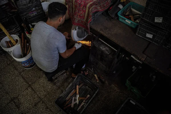 Eid Adhaの準備 2023年6月25日パレスチナ パレスチナ人労働者は パレスチナ人の肉屋のためのナイフや鋭利なツールの研磨と準備に特化ガザストリップの中心部にあるアル ファリの店内で働く — ストック写真