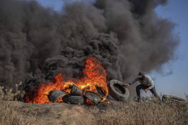 (Filistinli gençler Gazze Şeridi 'nin doğu sınırı boyunca lastik lastikleri ateşe verdiler. 3 Temmuz 2023, Gazze, Filistin: Filistinli gençler öfkelerini ifade etmek için Doğu Gazze sınırında lastik lastik lastik yakıyorlar 
