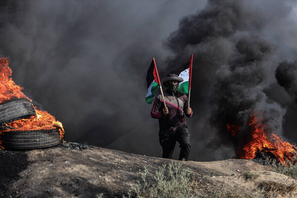 (INT) Palestinian youths set fire to rubber tires along the eastern border of the Gaza Strip. July 3, 2023, Gaza, Palestine: Palestinian youths are burning rubber tires on the eastern Gaza border to express their anger 