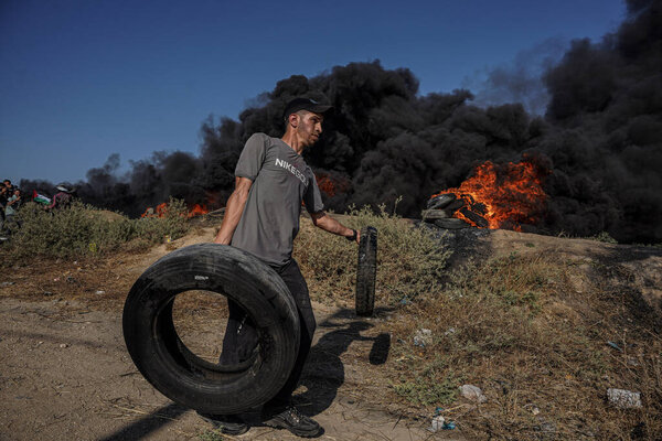 (INT) Palestinian youths set fire to rubber tires along the eastern border of the Gaza Strip. July 3, 2023, Gaza, Palestine: Palestinian youths are burning rubber tires on the eastern Gaza border to express their anger 