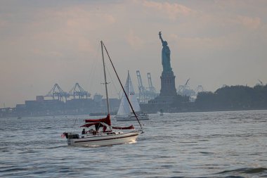 New York, ABD - 07 / 03 / 2023 - İklim / TRANSFERENCE / NEW YORK / USA - Özgürlük Heykeli Özgürlük Adası 'nda ve New York Limanı' nda tekne. Battery Park 'tan görüntü