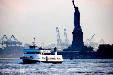 New York, ABD - 07 / 03 / 2023 - İklim / TRANSFERENCE / NEW YORK / USA - Özgürlük Heykeli Özgürlük Adası 'nda ve New York Limanı' nda tekne. Battery Park 'tan görüntü