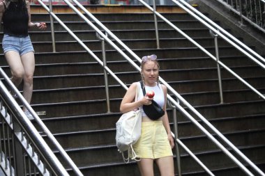 New Yorklular 4 Temmuz 'u Yağmur Altında Kutluyor. 4 Temmuz 2023, New York, ABD: Birçok New Yorklu ve turist, metro istasyonunda mahsur kaldıklarında yağmurdan korunmak için farklı yollar geliştirmek zorunda kaldılar.