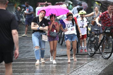 New Yorklular 4 Temmuz 'u Yağmur Altında Kutluyor. 4 Temmuz 2023, New York, ABD: Birçok New Yorklu ve turist, metro istasyonunda mahsur kaldıklarında yağmurdan korunmak için farklı yollar geliştirmek zorunda kaldılar.