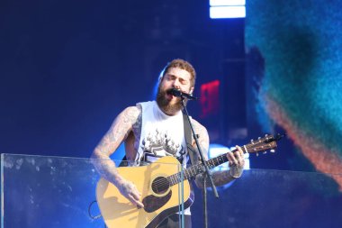 Post Malone Performing live on TSX Stage at Times Square. July 18, 2023, New York, USA: American rapper Austin Richard Post, known as Post Malone, is performing live at Times Square's TSX stage amidst severe weather with lots of fans 