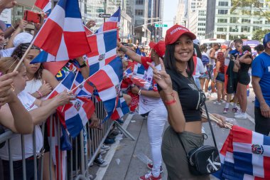 41. Ulusal Dominik Günü Geçidi 2023. 13 Ağustos 2023, New York, New York, ABD: Katılımcı, 13 Ağustos 2023 'te New York' ta 6. Cadde 'deki Dominik Günü Geçit Töreni' nde seyircilere bayrak dağıttı. 