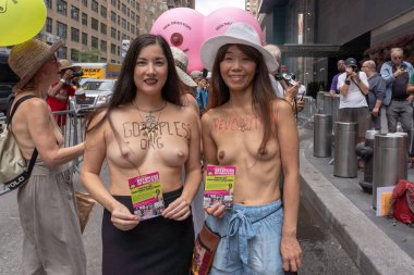 GoÜstsüz Gün Yürüyüşü. 26 Ağustos 2023, New York, New York, ABD: (EDITORS NOTE: Görüntü: Çıplaklık içerir) Yürüyüşçüler 26 Ağustos 2023 'teki GoTopless Day yürüyüşü sırasında bir jipin üzerine yapıştırılmış iki büyük göğse broşür tutuyorlar. 