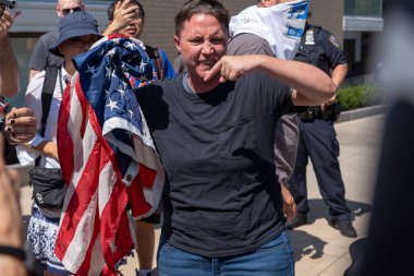 Gracie Malikanesi 'nin dışındaki Göçmen Krizi Protestocuları Çatışması. 27 Ağustos 2023, New York, New York, ABD: 27 Ağustos 2023 'te Gracie Malikanesi' nin önünde bir göçmen karşıtı miting ve protesto sırasında bir Amerikan Bayrağı üzerinde karşı-protestocu pulları