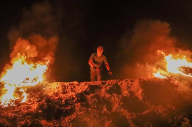 Devrimci bir genç, işgal hapishanelerinde cesur mahkumlarla birlikte duruyor. 12 Eylül 2023 Gazze, Filistin: Genç devrimciler, İsrail işgal hapishanelerindeki cesur mahkumlarla bağlantılı olarak sınır şeridi boyunca lastik lastik lastik yakıyorlar