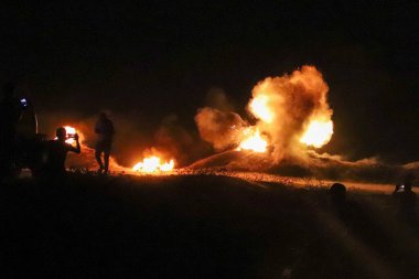 Devrimci bir genç, işgal hapishanelerinde cesur mahkumlarla birlikte duruyor. 12 Eylül 2023 Gazze, Filistin: Genç devrimciler, İsrail işgal hapishanelerindeki cesur mahkumlarla bağlantılı olarak sınır şeridi boyunca lastik lastik lastik yakıyorlar