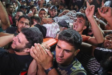 13 Eylül 2023, Gazze, Filistin: Filistinliler, İsrail sınırındaki çit yakınlarında meydana gelen patlamada ölen insanların cesetlerini taşıdılar. 