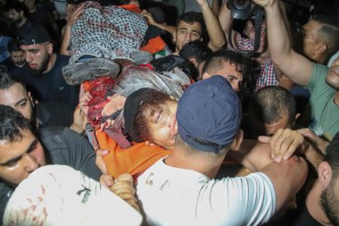 September 13, 2023, Gaza, Palestine: Palestinians carry the bodies of men killed during an explosion near the border fence with Israel.  clipart