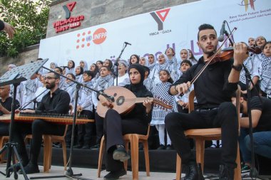 (Filistinliler müzikal bir kutlamaya katılıyorlar. 17 Eylül 2023, Gazze, Filistin: Filistinliler, Geleceği Kurtarma Projesi tarafından gerçekleştirilen gençlik liderlik projesine bir koro ekibinin katıldığı müzikal bir kutlamaya katıldılar