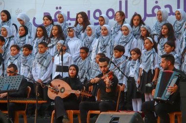 (Filistinliler müzikal bir kutlamaya katılıyorlar. 17 Eylül 2023, Gazze, Filistin: Filistinliler, Geleceği Kurtarma Projesi tarafından gerçekleştirilen gençlik liderlik projesine bir koro ekibinin katıldığı müzikal bir kutlamaya katıldılar