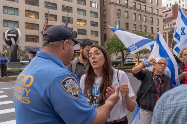 İsrailli gurbetçiler ve ABD 'li Yahudiler Başbakan Netanyahu' nun BM ziyareti sırasında protesto gösterisi düzenlediler. 21 Eylül 2023, New York, New York, ABD: Adli revizyon muhalefetinde bir NYPD Toplum İlişkileri memuruyla bir organizatör görüşüyor 