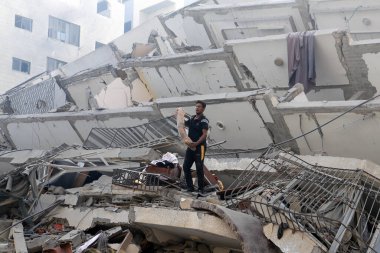 Filistinliler, 8 Ekim 2023 'te İsrail' in Gazze 'deki hava saldırıları sonucu yıkılan Watan Kulesi' nin kalıntılarını inceliyorlar. Gazze, Filistin: Filistinliler, İsrail 'in Gazze' deki hava saldırıları sonucu yıkılan Watan Kulesi 'nin kalıntılarını inceliyor