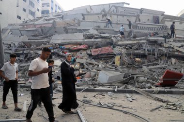 Filistinliler, 8 Ekim 2023 'te İsrail' in Gazze 'deki hava saldırıları sonucu yıkılan Watan Kulesi' nin kalıntılarını inceliyorlar. Gazze, Filistin: Filistinliler, İsrail 'in Gazze' deki hava saldırıları sonucu yıkılan Watan Kulesi 'nin kalıntılarını inceliyor
