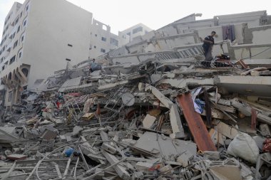 Filistinliler, 8 Ekim 2023 'te İsrail' in Gazze 'deki hava saldırıları sonucu yıkılan Watan Kulesi' nin kalıntılarını inceliyorlar. Gazze, Filistin: Filistinliler, İsrail 'in Gazze' deki hava saldırıları sonucu yıkılan Watan Kulesi 'nin kalıntılarını inceliyor