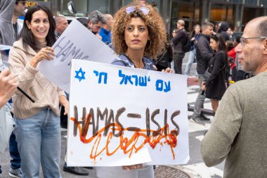 Hamas saldırısından sonra İsrail yanlısı mitingler New York 'ta yapıldı. 8 Ekim 2023, New York, New York, ABD: Bir kadın, 8 Ekim 2023 'te New York' ta İsrail konsolosluğu yakınlarındaki İsrail yanlısı bir konsoloslukta Hamas-IŞİD tabelası tutuyor..   
