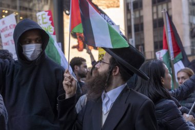 (Filistin yanlısı aktivistler, bir günlük eylem için toplanıyor. 13 Ekim 2023, New York, New York, ABD: Bir Neturei Karta üyesi bir anti-Siyonist Ortodoks Yahudi tarikatı, Times Meydanı 'nda bir Filistin Eylem Günü protestosu sırasında Filistin bayrağı tutuyor 