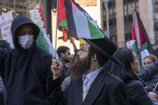 stock image (NEW) Pro-Palestinian Activists Gather For A Day Of Action. October 13, 2023, New York, New York, USA: A member of Neturei Karta an anti-Zionist Orthodox Jews Cult holds a Palestinian flag during a Palestinian a Day of Action protest in Times Square 