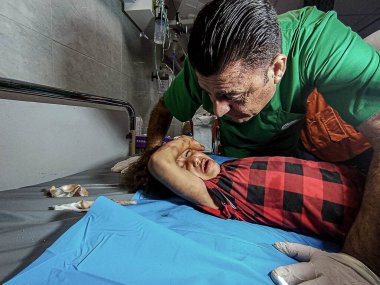GAZA (PALESTINE), 10 / 30 / 2023 - Filistin Kızıl Hilal Derneği 'nden tıbbi ekipler Gazze' nin güneyindeki Han Yunus ilindeki bir binaya saldırırken çocukları enkazdan kurtardılar 