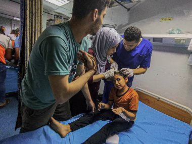 GAZA (PALESTINE), 10 / 30 / 2023 - Filistin Kızıl Hilal Derneği 'nden tıbbi ekipler Gazze' nin güneyindeki Han Yunus ilindeki bir binaya saldırırken çocukları enkazdan kurtardılar 