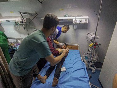 GAZA (PALESTINE), 10 / 30 / 2023 - Filistin Kızıl Hilal Derneği 'nden tıbbi ekipler Gazze' nin güneyindeki Han Yunus ilindeki bir binaya saldırırken çocukları enkazdan kurtardılar 