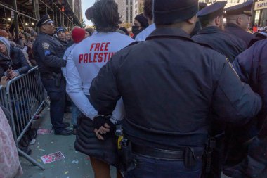 Filistinli protestocular Macy 'nin Şükran Günü Geçit Töreni' ni durdurmaya zorladı. 23 Kasım 2023, New York, New York, ABD: Tutuklu protestocular NYPD polis memurları ve Macy 'nin Şükran Günü Geçidi tarafından kaçırılıyor