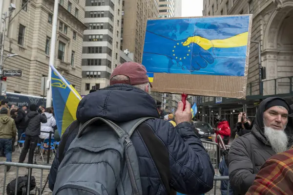亚当斯市长在乌克兰升旗仪式上致辞 2024年2月24日 美国纽约 在俄罗斯入侵乌克兰两周年之际 一名男子在乌克兰升旗仪式上举着标语 — 图库照片
