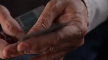 Rio de Janeiro (RJ), Brezilya - 03 / 10 / 2024 - Para Aklama 'nın resimsel resmi ve çamaşır ipinde kurumuş gerçek banknotlar. Bozuk paralar yıkılıyor ve birinin eli yasadışı para sayıyor. 100 real Reais banknotları.