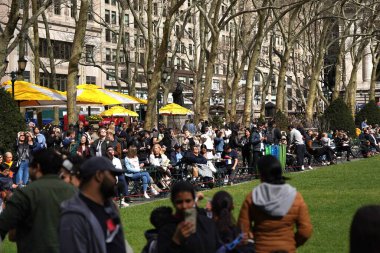 New York 'un Güneş Tutulması: Bryant Park' ta Fevkalade Bir Öğleden Sonra, 08 Nisan 2024, Manhattan, New York, ABD: Güneş tutulması New York şehrinin gökyüzünde görülürken, ay, güneş boyunca yolculuğuna başladı