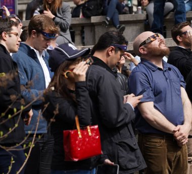 New York 'un Güneş Tutulması: Bryant Park' ta Fevkalade Bir Öğleden Sonra, 08 Nisan 2024, Manhattan, New York, ABD: Güneş tutulması New York şehrinin gökyüzünde görülürken, ay, güneş boyunca yolculuğuna başladı