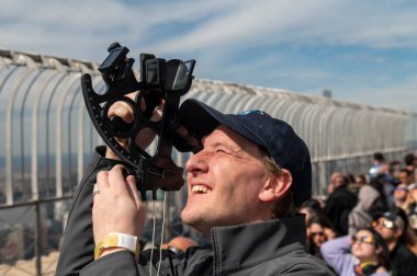 Solar Eclipse 2024 in New York City. April 08, 2024, New York, New York, USA: David Souther uses a sextant to view the partial solar eclipse from the 86th floor Observation deck of the Empire State Building on April 8, 2024 in New York City.  clipart