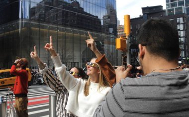 New York 'ta Güneş Tutulması. 08 Nisan 2024, New York, ABD: New Yorklular ve turistler Manhattan 'da güneş tutulmasını izlerken görüldü. Ay, Dünya ile Güneş arasında geçtiğinde bir güneş tutulması meydana gelir.