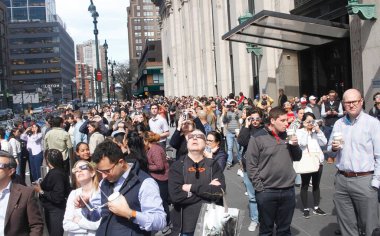 New York 'ta Güneş Tutulması. 08 Nisan 2024, New York, ABD: New Yorklular ve turistler Manhattan 'da güneş tutulmasını izlerken görüldü. Ay, Dünya ile Güneş arasında geçtiğinde bir güneş tutulması meydana gelir.