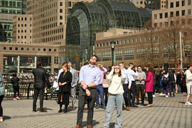 8 Nisan 2024 - New York, ABD: New York 'ta 2024 Güneş tutulması. Çok beklenen güneş tutulması, ay, güneş ve dünya arasından geçerken güneş ışınlarını engellediğinde ortaya çıkacak. Özel güneş gözlüğü takan insanlar 
