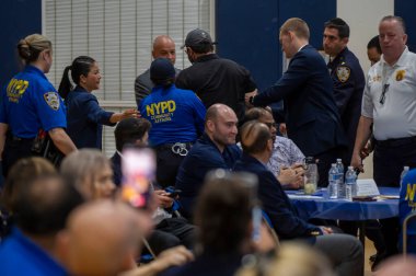 Mayor Adams Hosts Community Conversation. May 28, 2024, New York, New York, USA: A demonstrator is escorted out by NYPD Police Officers after he interrupted a speech by New York City Mayor Eric Adams at Frank Sinatra School of the Arts High School clipart