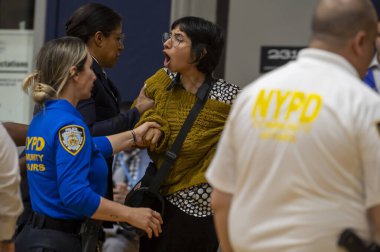Mayor Adams Hosts Community Conversation. May 28, 2024, New York, New York, USA: A demonstrator is escorted out by NYPD Police Officers after he interrupted a speech by New York City Mayor Eric Adams at Frank Sinatra School of the Arts High School clipart