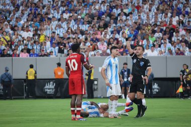 Copa America Yarı Finali: Arjantin Kanada 'ya karşı. 9 Temmuz 2024, Doğu Rutherford, New Jersey, ABD: Kanadalı Jonathan Christian David, Arjantin ile Kanada arasındaki futbol maçında hakem Maza Gomez, Piero 'dan (Şili) sarı kart aldı.