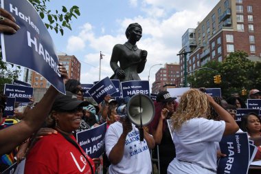 Arka planda Harriet Tubman 'ın heykeliyle, Başkan Yardımcısı Kamala Harris' i destekleyen bir Harlem siyahi kadın örgütü, Başkan Joe Biden 'ın yeniden seçilmemeye karar vermesinden sonra. 28 Temmuz 2024, New York
