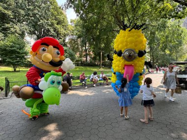 (NEW) Balloon Story at Central Park. August 15, 2024, New York, USA: Balloon Story displaying characters like Mario, Yoshi and Mania at Central Park, on their way to the Balloon Story exhibition at Armory on 66 and Park clipart