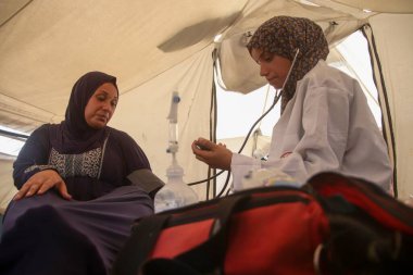 Jenin Abu Zarqa Providing Medical Help to Pregnant Women in Gaza. August 19, 2024, Gaza, Palestine: A 22 years old Palestinian nurse; Jenin Abu Zarqa, who graduated from the nursing school in 2023, opens a medical tent to examine pregnant women clipart