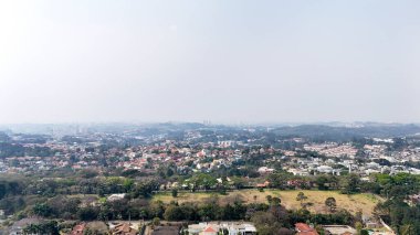 Sao Paulo, Brezilya 09 / 03 / 2024 - Cotia Granja Vianna bölgesinin havadan görünüşü, arka planda Sao Paulo şehri, kuru hava ve sis ile kaplı, bu 3 Eylül 2024 Salı,.