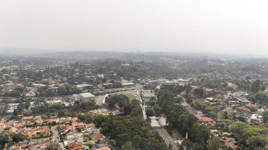 Cotia (SP), 09.10.2024 - Cotia 'daki Granja Vianna mahallesinin havadan görünüşü ve 10 Eylül 2024 sabahı arka planda Sao Paulo şehrindeki gökyüzünü kaplayan kuru hava kirliliği.