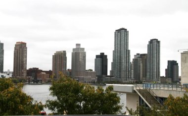 Gökdelenler Adorn New York Şehri İskelesi. 25 Eylül 2024, New York, ABD: New York şehrinin rıhtımdaki gökdelenlerinin güzel görüntüsü bulutlu gökyüzünün ortasında ihmal edilmesi zor ve çekici bir resim (niyi fote / thews2)