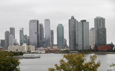 Gökdelenler Adorn New York Şehri İskelesi. 25 Eylül 2024, New York, ABD: New York şehrinin rıhtımdaki gökdelenlerinin güzel görüntüsü bulutlu gökyüzünün ortasında ihmal edilmesi zor ve çekici bir resim (niyi fote / thews2)