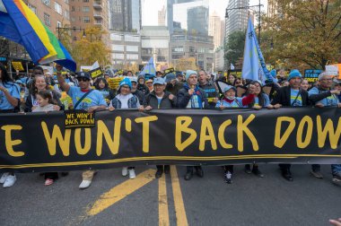 (Yeni göçmenler ve aktivistler, yaklaşan Trump yönetimine karşı dayanışma içinde. 9 Kasım 2024, New York, New York, ABD: Göçmenler ve aktivistler bir miting sırasında Central Park 'ın güneyine yürüyorlar (m10 / thenews2)